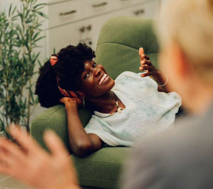 Two women engaged in conversation on a couch.